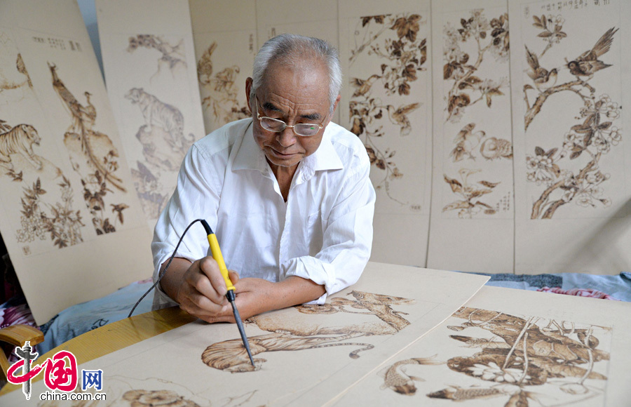 7月30日,河北省邯郸市邯郸县榆林村民间艺人张振芳正在用电烙铁作画。 7月30日,河北省邯郸市邯郸县榆林村民间艺人张振芳正在用电烙铁作画。